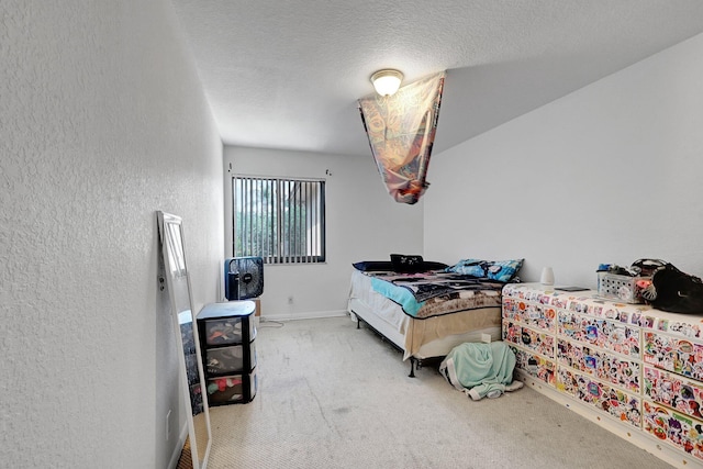 bedroom featuring a textured wall, baseboards, carpet, and a textured ceiling