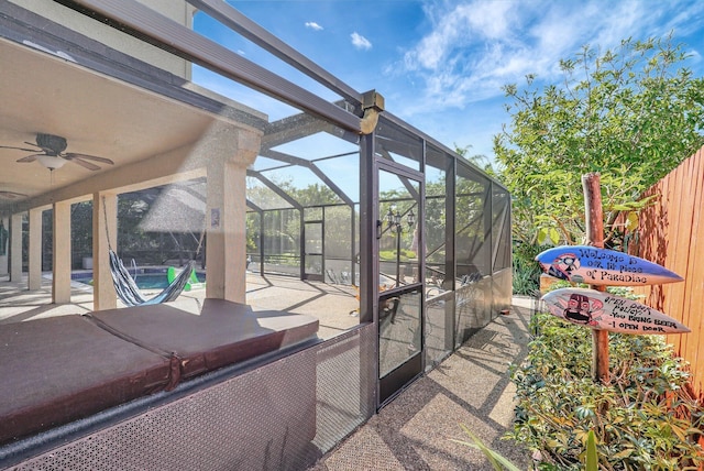 view of patio / terrace with glass enclosure, an outdoor pool, a ceiling fan, and fence