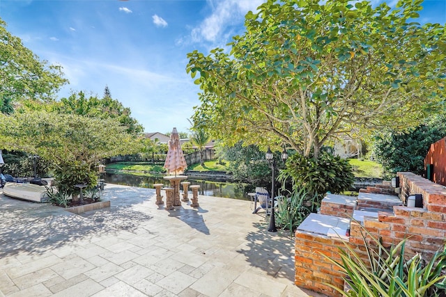 view of patio / terrace featuring fence and a water view