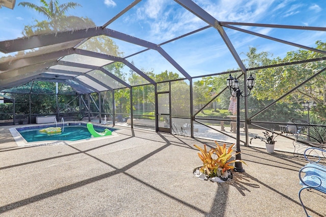 pool with glass enclosure and a patio area