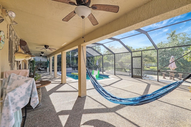 view of patio / terrace featuring an outdoor pool, glass enclosure, and ceiling fan