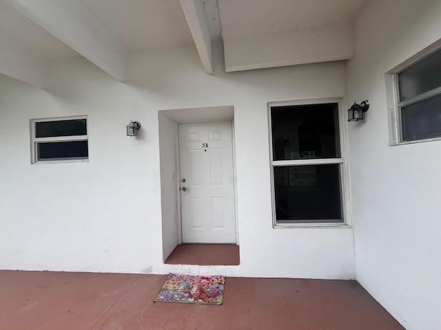 property entrance with stucco siding