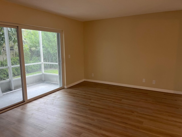 unfurnished room featuring baseboards and wood finished floors