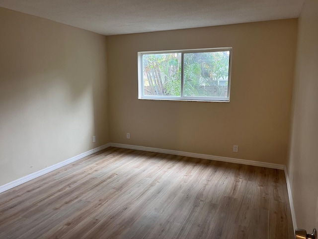 empty room with baseboards and wood finished floors