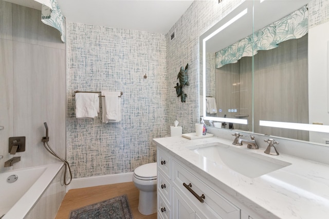 full bath featuring toilet, vanity, baseboards, and wood finished floors