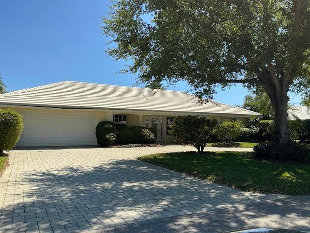 ranch-style home featuring decorative driveway and a garage