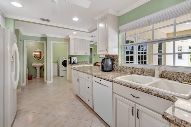 kitchen with white cabinetry, white appliances, washer / clothes dryer, and a sink