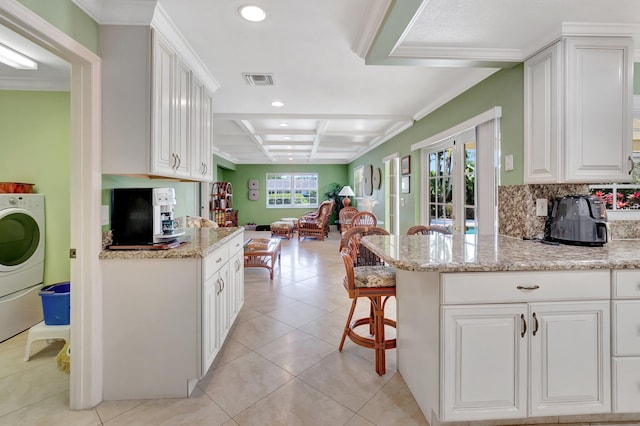 kitchen featuring light tile patterned floors, visible vents, coffered ceiling, a kitchen bar, and open floor plan