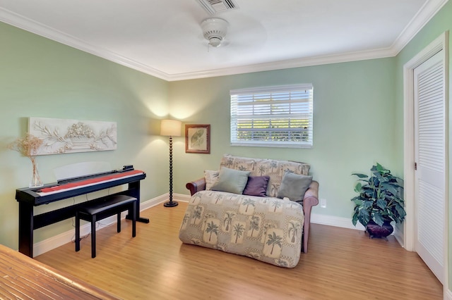 sitting room with visible vents, ornamental molding, and wood finished floors