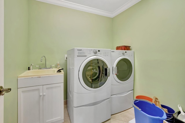 laundry area with ornamental molding, light tile patterned floors, cabinet space, washer and dryer, and a sink