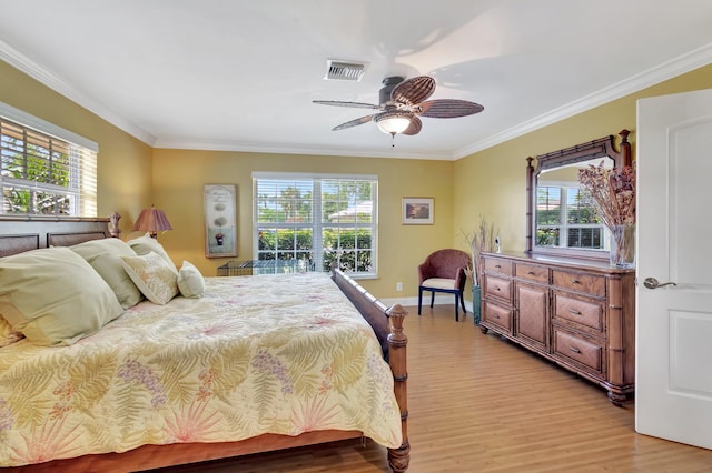 bedroom featuring light wood-type flooring, multiple windows, visible vents, and ornamental molding