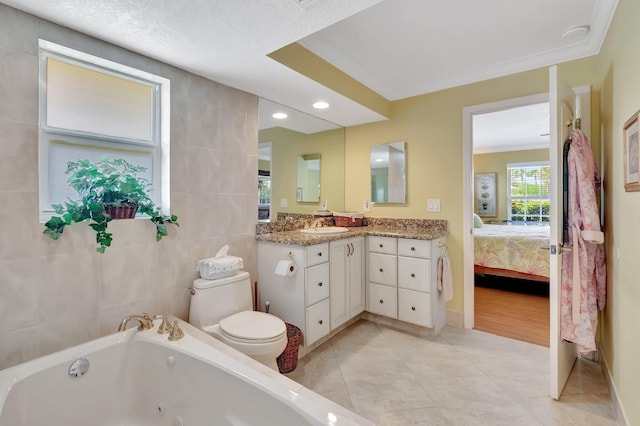 full bath with tile walls, toilet, a whirlpool tub, tile patterned floors, and vanity