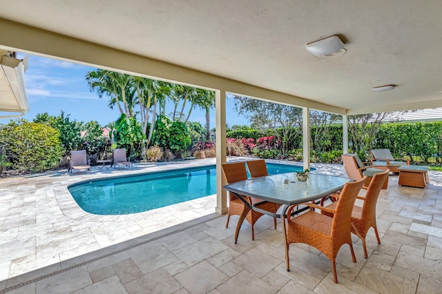 outdoor pool featuring outdoor dining space, a patio, and fence