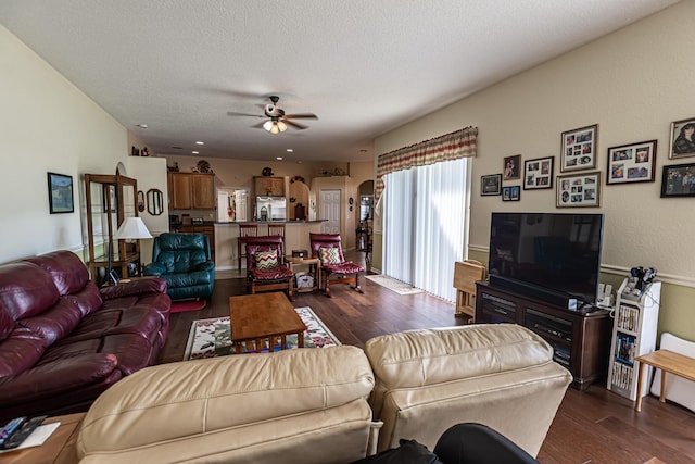 6496 NW Groveland Ter, Port Saint Lucie, FL 34986 - living area featuring dark wood-style floors, arched walkways, a textured ceiling, and ceiling fan