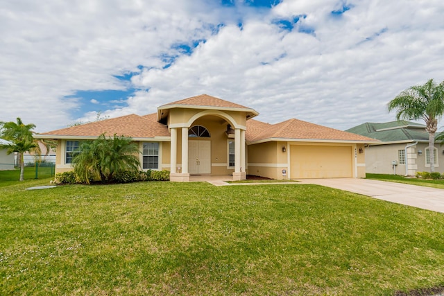 6496 NW Groveland Ter, Port Saint Lucie, FL 34986 - mediterranean / spanish home with stucco siding, a front lawn, fence, concrete driveway, and an attached garage