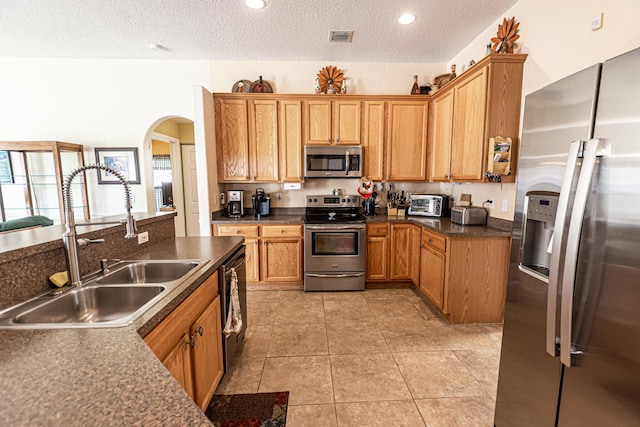 6496 NW Groveland Ter, Port Saint Lucie, FL 34986 - kitchen featuring visible vents, light tile patterned floors, appliances with stainless steel finishes, arched walkways, and a sink
