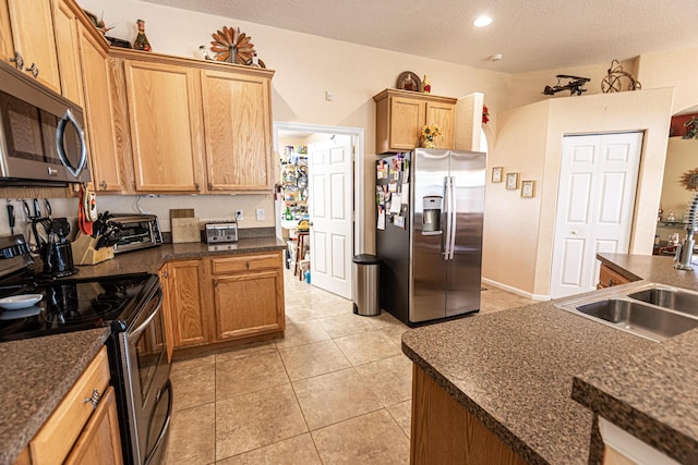 6496 NW Groveland Ter, Port Saint Lucie, FL 34986 - kitchen featuring light tile patterned floors, a sink, stainless steel appliances, a textured ceiling, and dark countertops