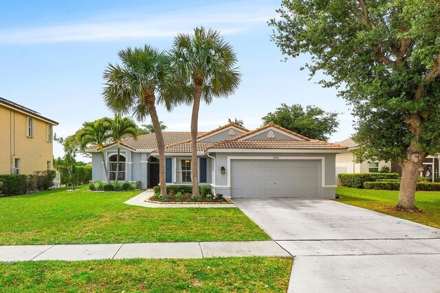 6346 Sand Hills Cir, Lake Worth, FL 33463 - view of front of property with an attached garage, stucco siding, a tile roof, a front lawn, and driveway