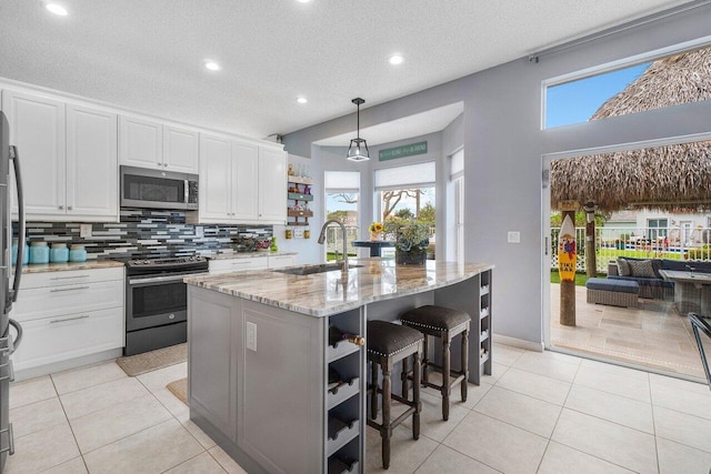 6346 Sand Hills Cir, Lake Worth, FL 33463 - kitchen with open shelves, light tile patterned floors, stainless steel appliances, a sink, and white cabinets