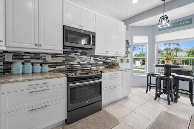 6346 Sand Hills Cir, Lake Worth, FL 33463 - kitchen featuring decorative backsplash, a textured ceiling, white cabinets, appliances with stainless steel finishes, and light tile patterned floors