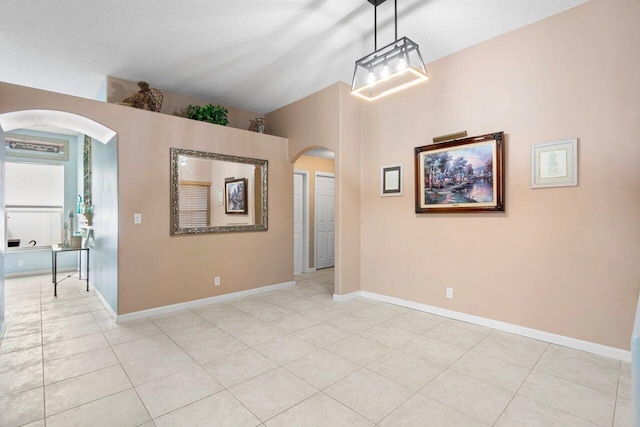 6346 Sand Hills Cir, Lake Worth, FL 33463 - empty room featuring light tile patterned floors, arched walkways, baseboards, and vaulted ceiling