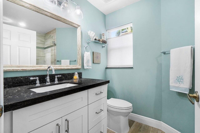 6346 Sand Hills Cir, Lake Worth, FL 33463 - bathroom featuring a tile shower, toilet, vanity, wood finished floors, and baseboards