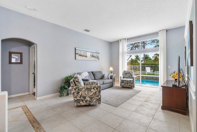 6346 Sand Hills Cir, Lake Worth, FL 33463 - living area featuring a textured ceiling, visible vents, baseboards, arched walkways, and light tile patterned floors