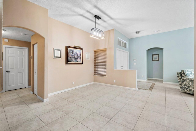 6346 Sand Hills Cir, Lake Worth, FL 33463 - empty room with light tile patterned flooring, baseboards, arched walkways, and a textured ceiling