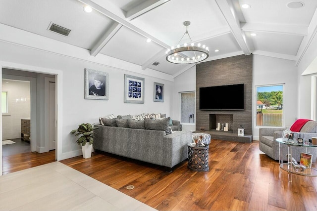 living room with hardwood / wood-style floors, baseboards, visible vents, and an inviting chandelier