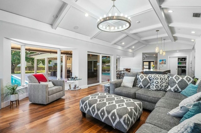 living area featuring an inviting chandelier, visible vents, lofted ceiling with beams, and wood finished floors