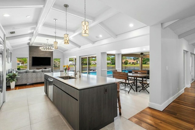 kitchen with visible vents, modern cabinets, a sink, open floor plan, and vaulted ceiling with beams