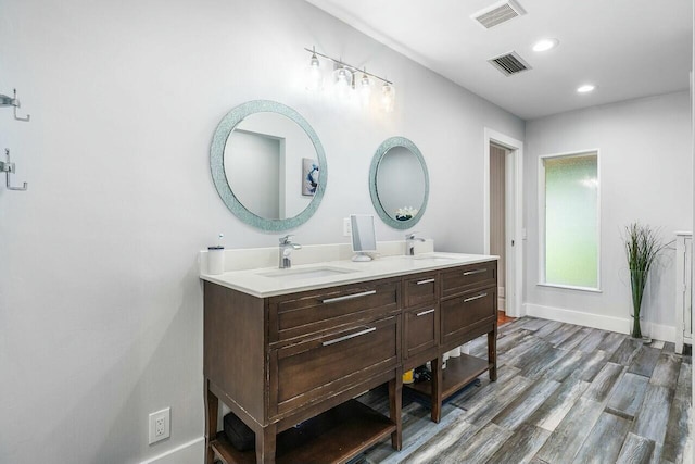 bathroom with visible vents, a sink, and wood finished floors