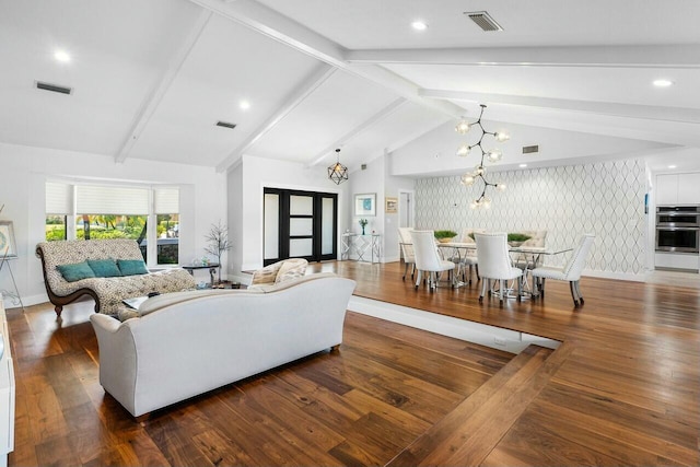 living room with visible vents, an inviting chandelier, wood finished floors, and lofted ceiling with beams