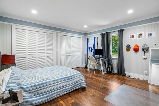bedroom with two closets, recessed lighting, baseboards, and wood finished floors