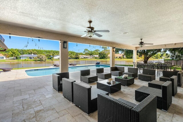 view of patio with an outdoor living space, fence, and a fenced in pool
