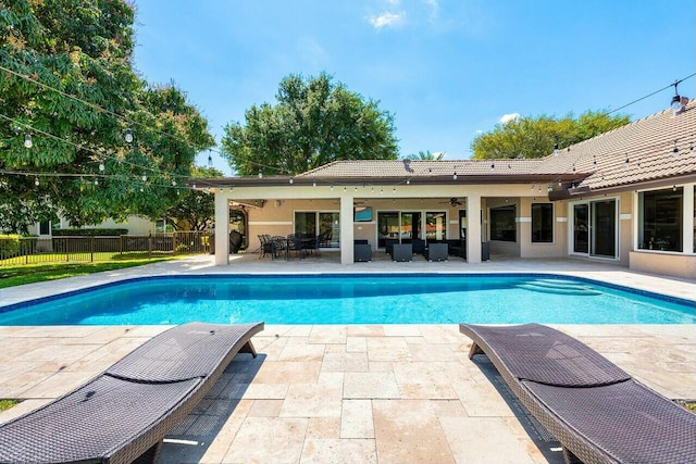 view of swimming pool featuring fence, an outdoor living space, a fenced in pool, ceiling fan, and a patio area