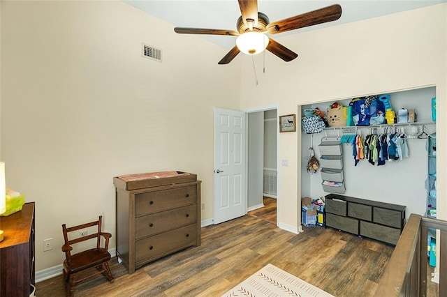 bedroom featuring visible vents, baseboards, wood finished floors, a closet, and a ceiling fan