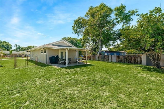 view of yard with a shed, a fenced backyard, an outbuilding, a patio, and a gate