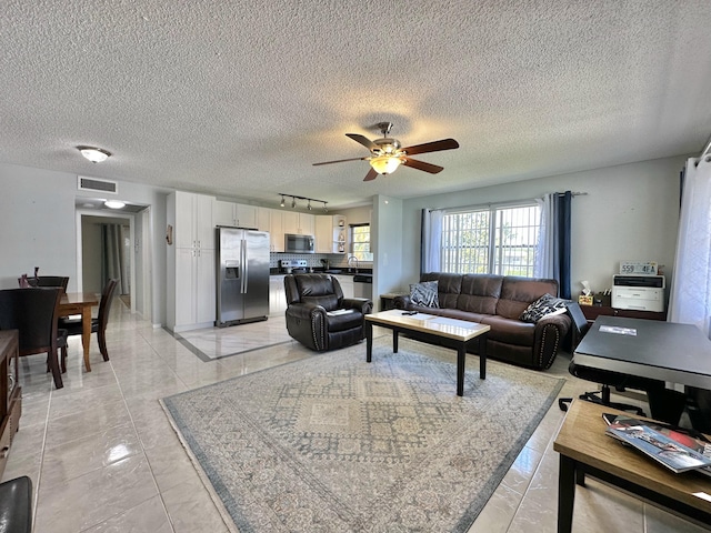 living area with visible vents, a textured ceiling, ceiling fan, and rail lighting