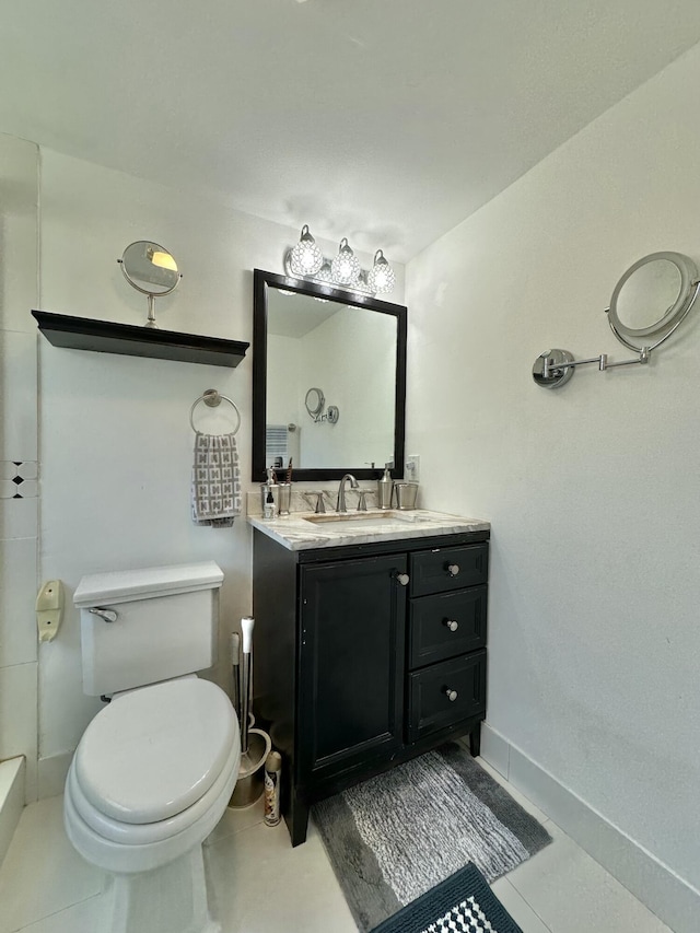 bathroom featuring tile patterned floors, baseboards, toilet, and vanity