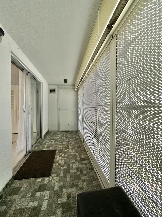 hallway featuring visible vents and a textured ceiling