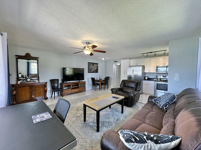 living room featuring a textured ceiling and a ceiling fan