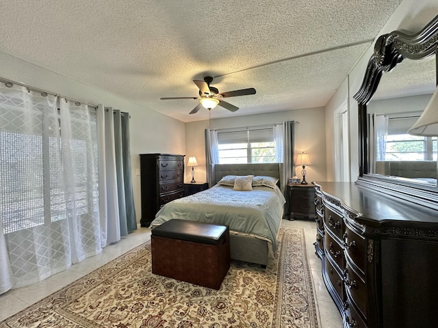 bedroom featuring light tile patterned floors, a textured ceiling, and ceiling fan