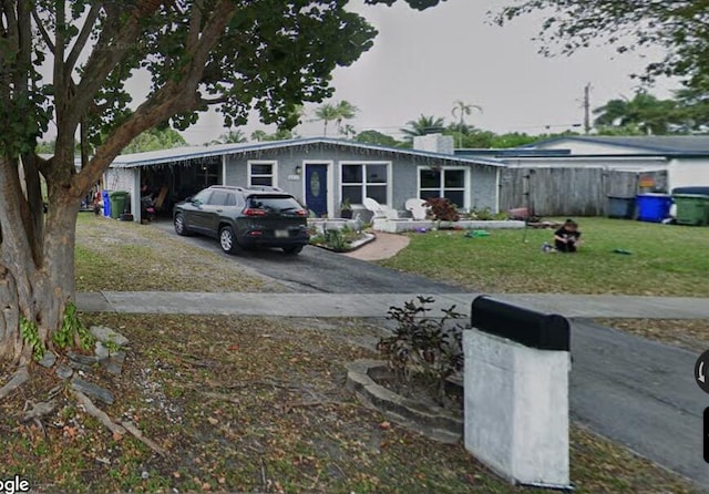 view of front facade with a front lawn, a chimney, and driveway