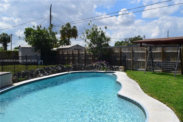 view of pool featuring a fenced in pool, a lawn, and fence