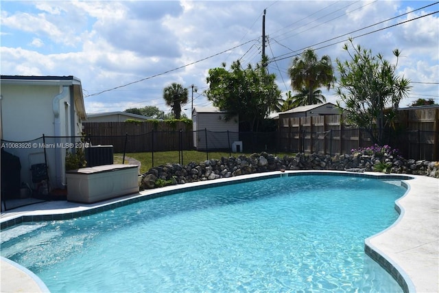 view of swimming pool with a fenced in pool, central AC unit, and a fenced backyard