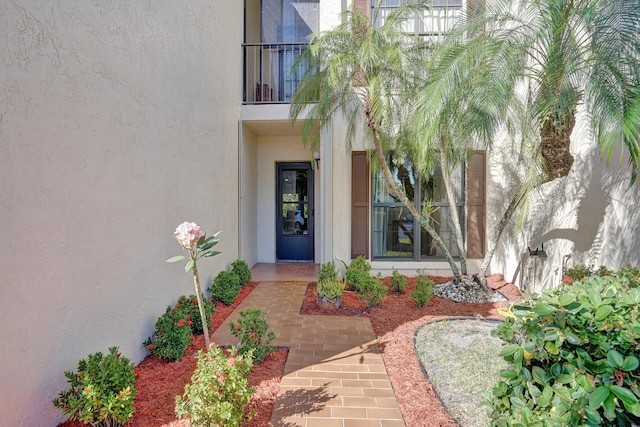 doorway to property with stucco siding and a balcony