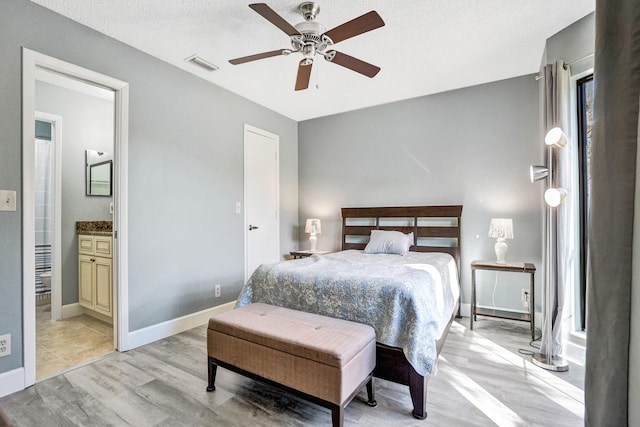 bedroom featuring visible vents, ceiling fan, baseboards, light wood-style floors, and a textured ceiling