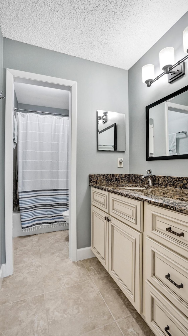 full bath featuring vanity, tile patterned flooring, a textured ceiling, curtained shower, and toilet