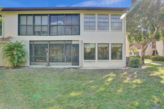 back of property featuring stucco siding and a yard